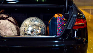 Black car at valet with disco ball in trunk - Best travel apps